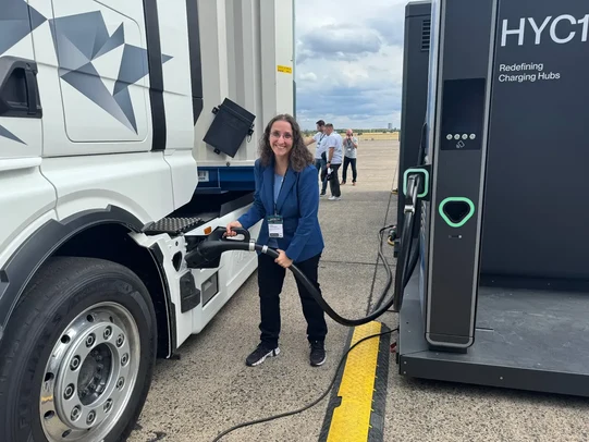 Anita Athanasas with an electric truck at a charging station