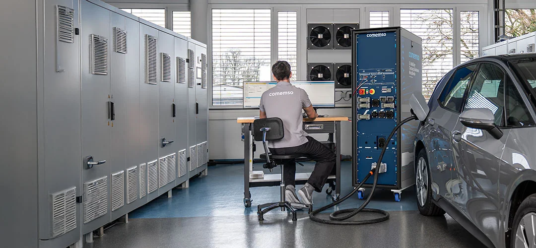 An electric vehicle connected to an EVCA test system: an engineer investigates charging behaviour in the lab