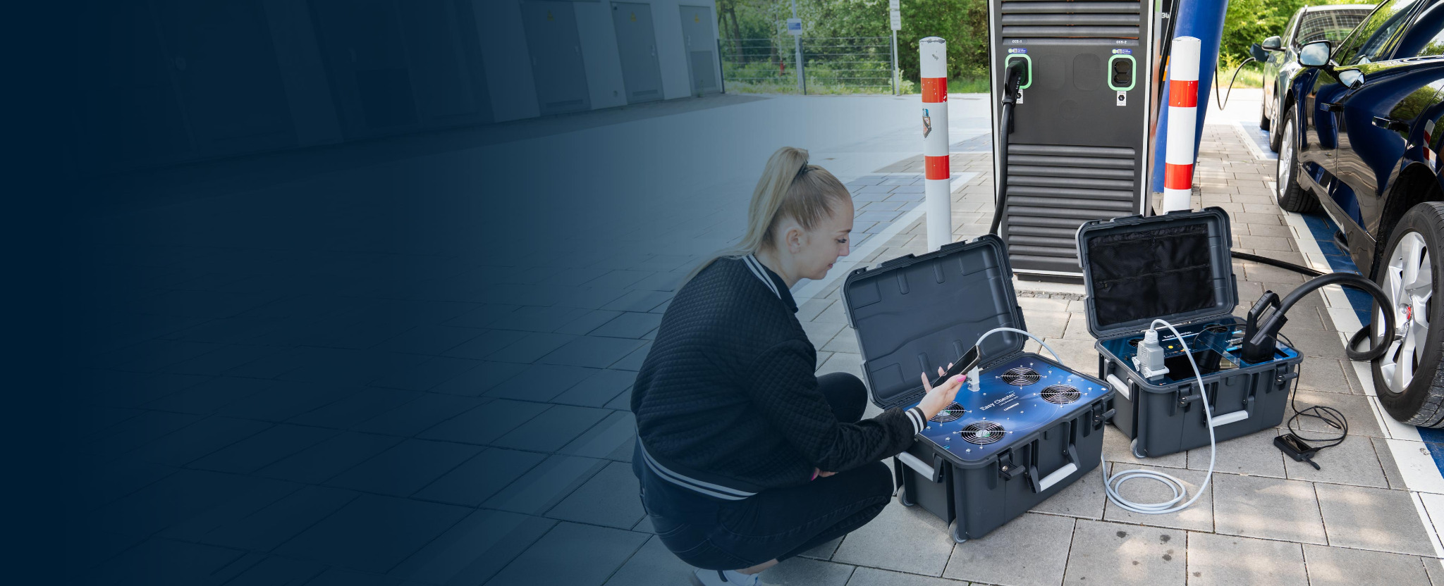 Techniker bereitet zwei tragbare comemso-Prüfsysteme an einer öffentlichen DC-Ladestation vor
